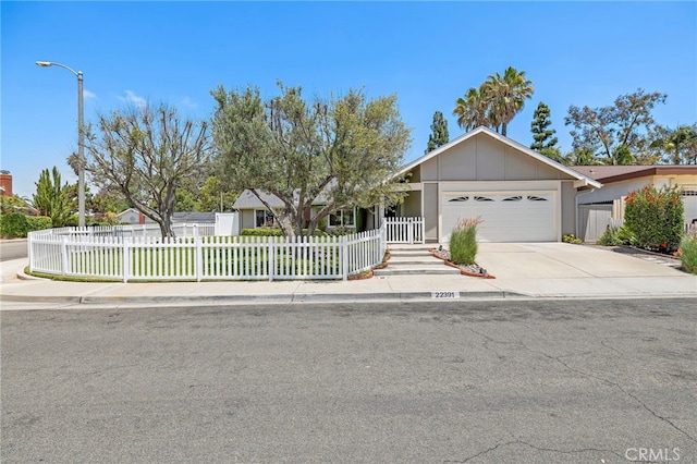 22391 Lombardi, Laguna Hills, CA 92653 - view of front of home with a garage, a fenced front yard, concrete driveway, and board and batten siding