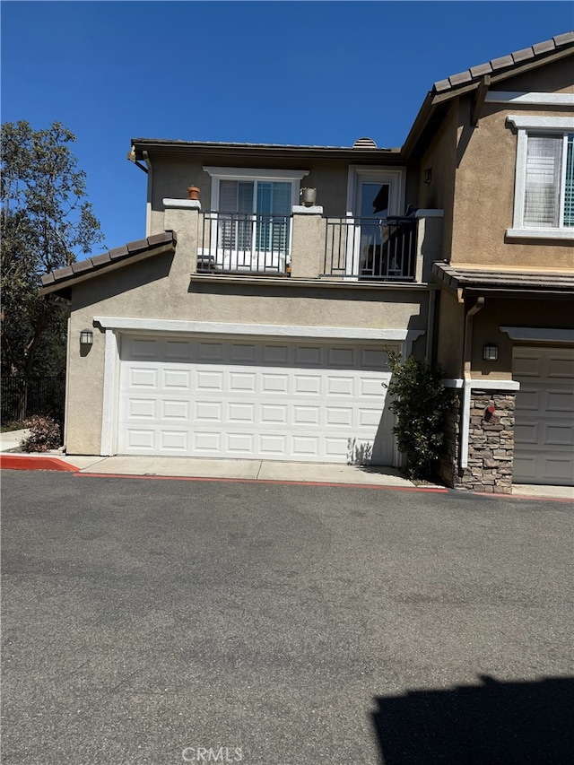 326 Borden Rd, San Marcos, CA 92069 - view of front of property with a balcony, stucco siding, a garage, and driveway