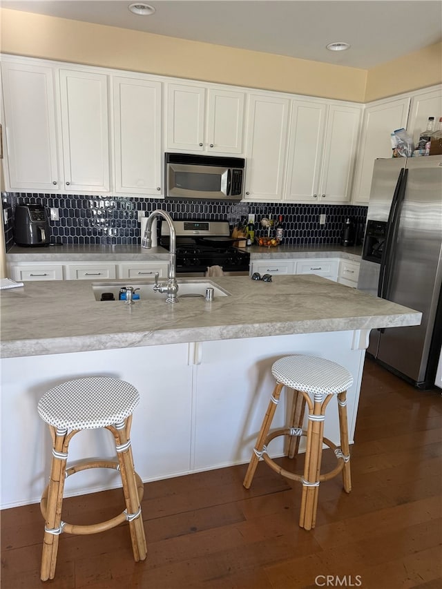 326 Borden Rd, San Marcos, CA 92069 - kitchen with stainless steel appliances, white cabinets, a breakfast bar, and recessed lighting
