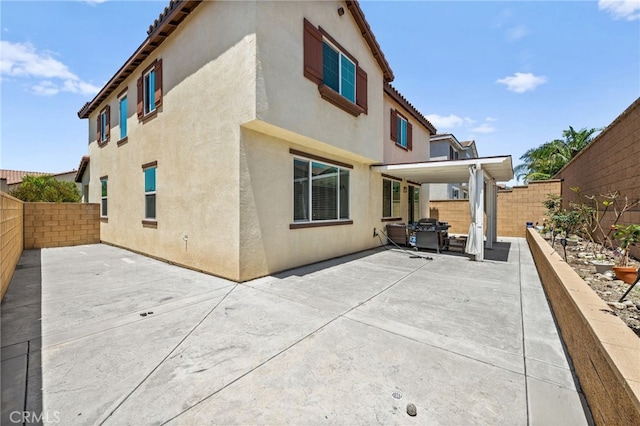 5609 Garibaldi Way, Fontana, CA 92336 - rear view of house with a patio, stucco siding, a fenced backyard, and a tile roof