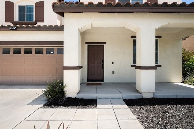 5609 Garibaldi Way, Fontana, CA 92336 - view of exterior entry featuring stucco siding, a tiled roof, a garage, and driveway