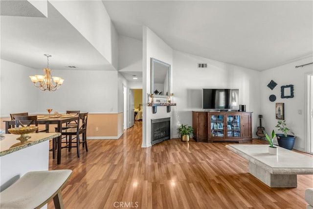6210 Hartford Rd Unit 201, Yorba Linda, CA 92887 - living room with light wood finished floors, a fireplace, a chandelier, and high vaulted ceiling