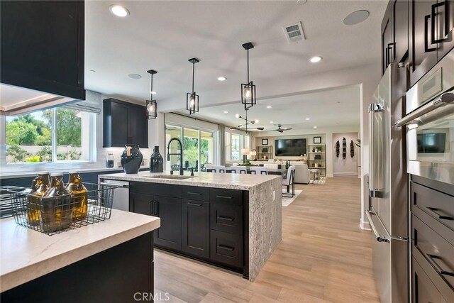 3091 Orchard Gln, Escondido, CA 92026 - kitchen with a center island with sink, recessed lighting, stainless steel appliances, decorative backsplash, and open floor plan