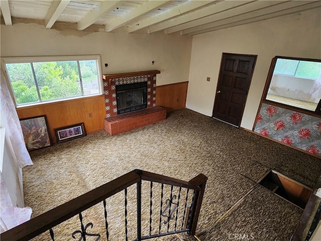 11860 W Trail Trail, Sylmar, CA 91342 - unfurnished living room with carpet, beam ceiling, a tiled fireplace, wooden walls, and a wainscoted wall