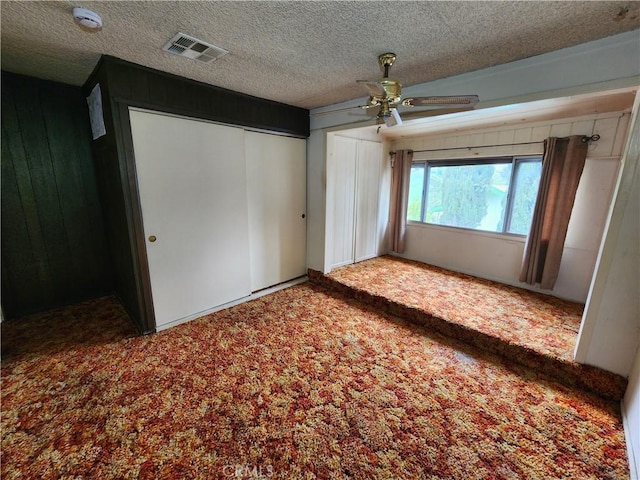 11860 W Trail Trail, Sylmar, CA 91342 - unfurnished bedroom with carpet, a textured ceiling, wood walls, and ceiling fan