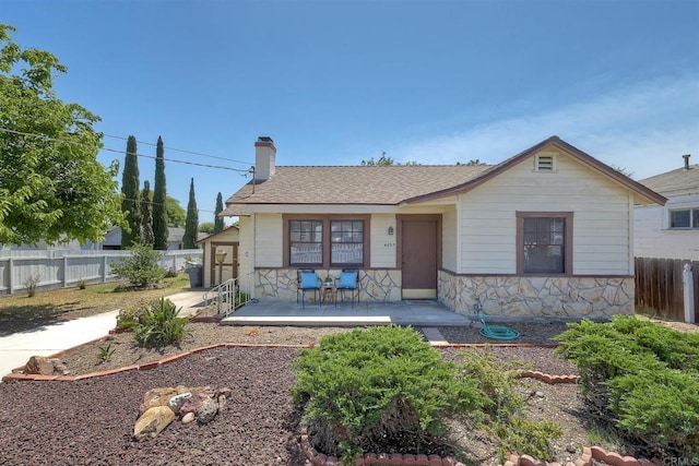 4693 71st St, La Mesa, CA 91942 - view of front facade with stone siding, a chimney, and roof with shingles