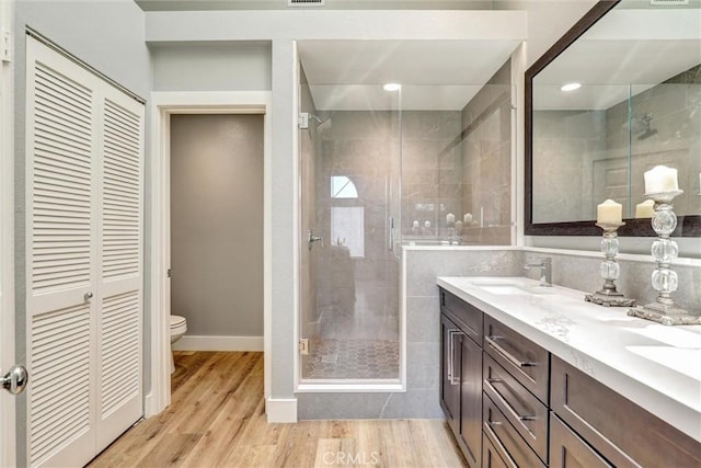25072 Leucadia St Unit E, Laguna Niguel, CA 92677 - bathroom featuring double vanity, a stall shower, wood finished floors, and a closet