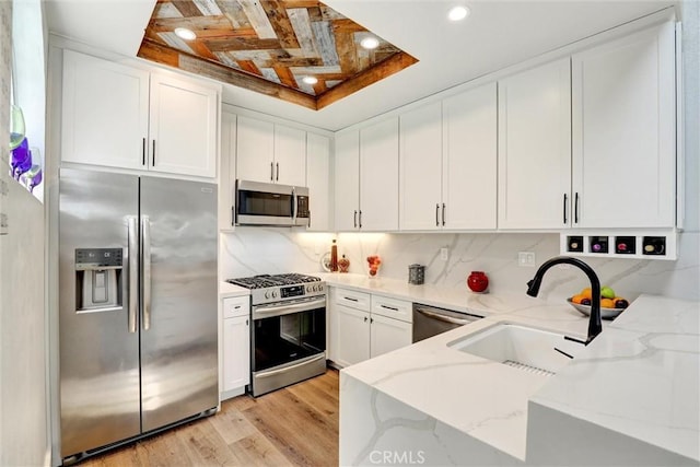 25072 Leucadia St Unit E, Laguna Niguel, CA 92677 - kitchen with stainless steel appliances, light stone countertops, white cabinetry, decorative backsplash, and recessed lighting