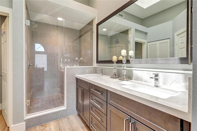 25072 Leucadia St Unit E, Laguna Niguel, CA 92677 - bathroom featuring double vanity, wood finished floors, and a stall shower