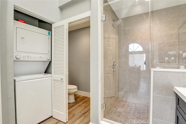 25072 Leucadia St Unit E, Laguna Niguel, CA 92677 - bathroom featuring stacked washer / dryer, a stall shower, vanity, and wood finished floors