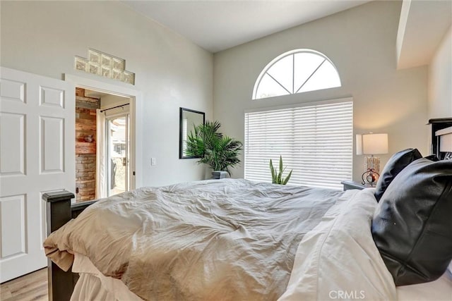 25072 Leucadia St Unit E, Laguna Niguel, CA 92677 - bedroom featuring multiple windows, light wood-type flooring, and a towering ceiling
