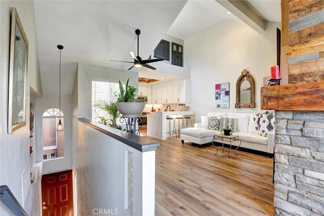 25072 Leucadia St Unit E, Laguna Niguel, CA 92677 - living room with high vaulted ceiling, a ceiling fan, and wood finished floors