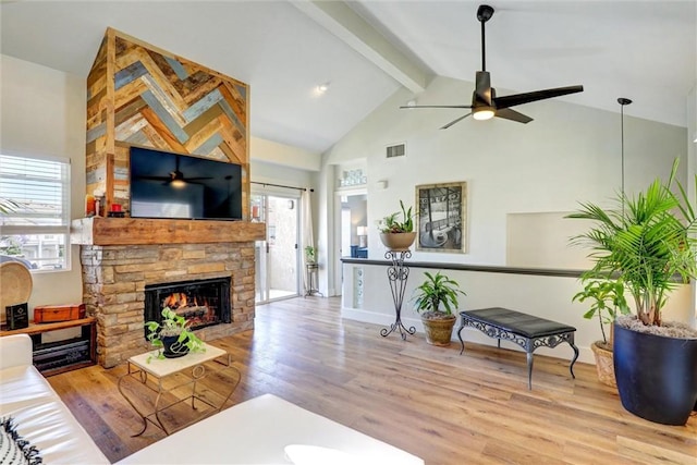 25072 Leucadia St Unit E, Laguna Niguel, CA 92677 - living area featuring a ceiling fan, high vaulted ceiling, beamed ceiling, wood finished floors, and a stone fireplace