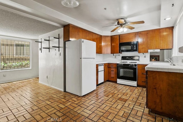 3431 Caspian Ave, Long Beach, CA 90810 - kitchen featuring white appliances, brown cabinetry, a ceiling fan, decorative backsplash, and tile counters