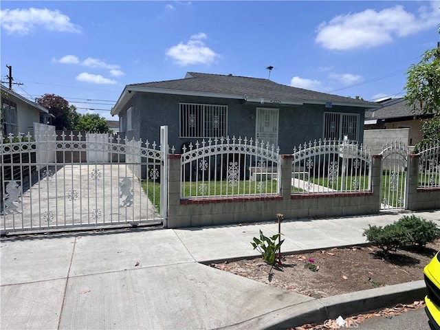 1222 E 103rd St, Los Angeles, CA 90002 - bungalow-style house featuring a gate, stucco siding, and a shingled roof