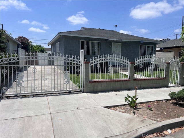 1222 E 103rd St, Los Angeles, CA 90002 - bungalow-style house featuring a gate, stucco siding, and a shingled roof