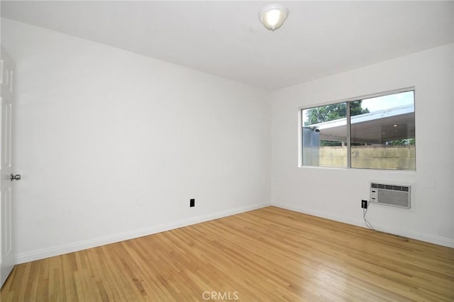 19324 Victory Blvd, Reseda, CA 91335 - empty room with an AC wall unit and light wood-style flooring