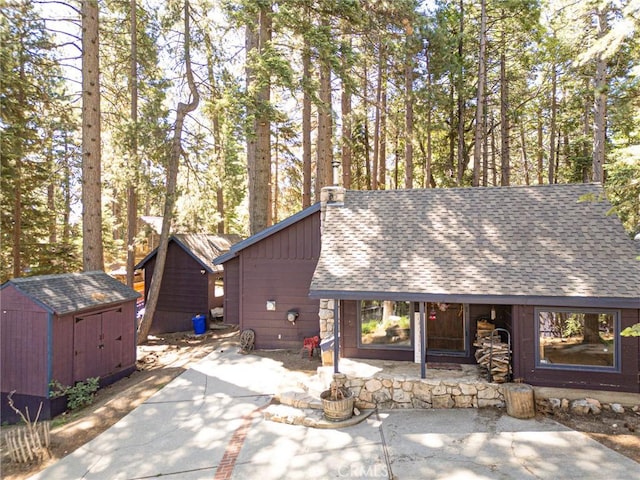 31701 Christmas Tree Ln, Running Springs, CA 92382 - view of front of property featuring a patio area, roof with shingles, and a shed