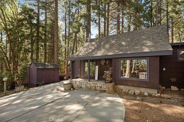 31701 Christmas Tree Ln, Running Springs, CA 92382 - view of front facade featuring roof with shingles, a patio, and a storage unit