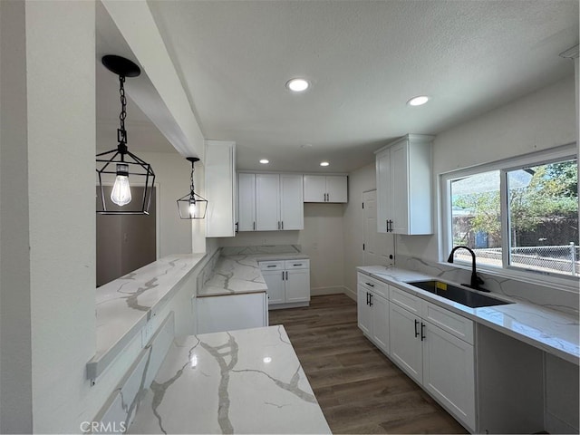 10615 Wolfe Ave, Riverside, CA 92505 - kitchen featuring light stone counters, white cabinets, dark wood-style floors, recessed lighting, and hanging light fixtures