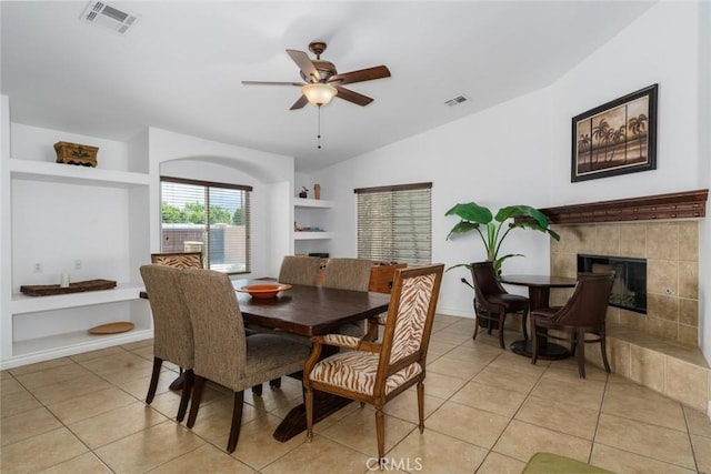 79140 Fred Waring Dr, Bermuda Dunes, CA 92203 - dining area featuring a ceiling fan, built in shelves, a fireplace, light tile patterned floors, and lofted ceiling