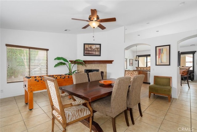 79140 Fred Waring Dr, Bermuda Dunes, CA 92203 - dining area featuring light tile patterned floors, arched walkways, ceiling fan, and a fireplace