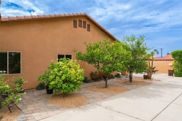 79140 Fred Waring Dr, Bermuda Dunes, CA 92203 - view of property exterior featuring a patio, stucco siding, and a tiled roof