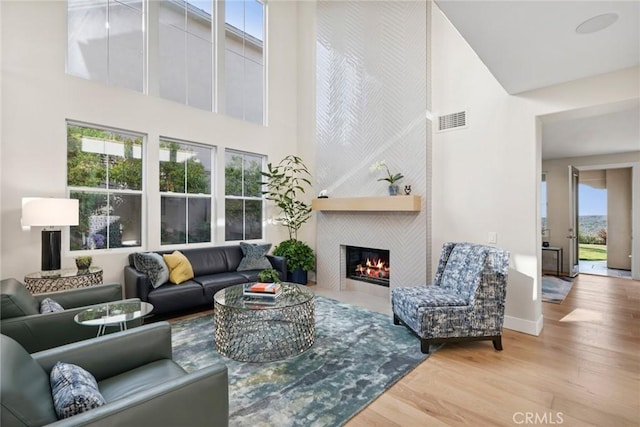 8 Pavona, Newport Coast, CA 92657 - living room with a fireplace, a high ceiling, and wood finished floors