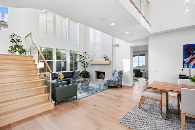 8 Pavona, Newport Coast, CA 92657 - living room featuring wood finished floors, stairway, a fireplace, a towering ceiling, and recessed lighting