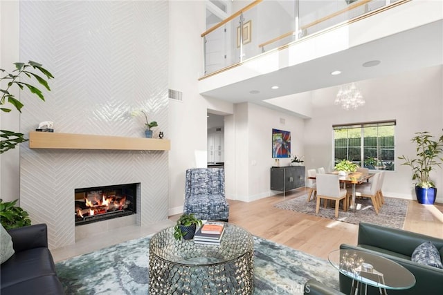 8 Pavona, Newport Coast, CA 92657 - living area with a high ceiling, a tile fireplace, wood finished floors, a chandelier, and an accent wall