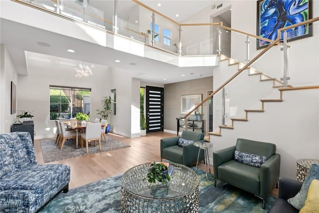 8 Pavona, Newport Coast, CA 92657 - living area with a towering ceiling, stairway, wood finished floors, a chandelier, and recessed lighting