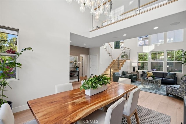 8 Pavona, Newport Coast, CA 92657 - dining area with a towering ceiling, healthy amount of natural light, stairs, light wood-style floors, and a chandelier