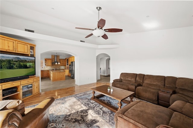 2240 Aqua Hill Rd, Fallbrook, CA 92028 - living room with arched walkways, a ceiling fan, and light wood-style flooring