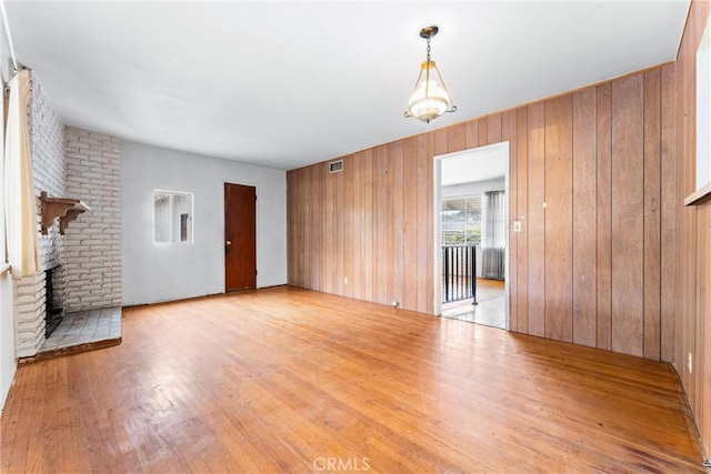 1305 S Westchester Dr, Anaheim, CA 92804 - unfurnished living room with wood finished floors, wooden walls, and a fireplace