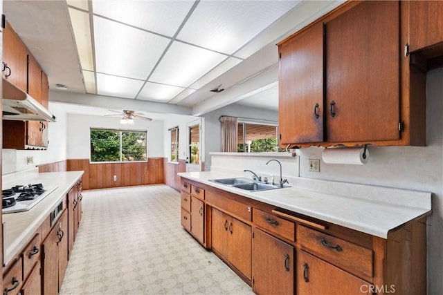 1305 S Westchester Dr, Anaheim, CA 92804 - kitchen with gas stovetop, a wainscoted wall, light countertops, wood walls, and plenty of natural light