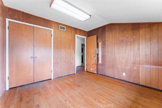 1305 S Westchester Dr, Anaheim, CA 92804 - unfurnished bedroom featuring wood finished floors, wooden walls, lofted ceiling, and a closet