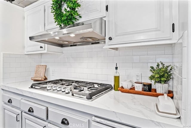 235 Bret Harte Rd, Lake Arrowhead, CA 92352 - kitchen with under cabinet range hood, white cabinetry, stainless steel gas cooktop, and decorative backsplash