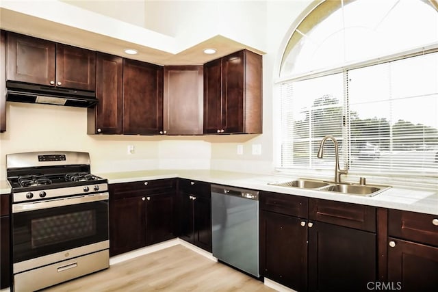 44930 11th St E, Lancaster, CA 93535 - kitchen featuring appliances with stainless steel finishes, range hood, light countertops, light wood-style flooring, and dark brown cabinets