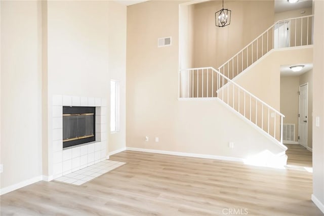 44930 11th St E, Lancaster, CA 93535 - unfurnished living room with wood finished floors, stairs, a high ceiling, and a fireplace
