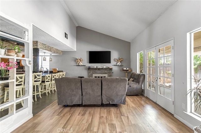4883 E Geary St, Fresno, CA 93725 - living area featuring wood finished floors, high vaulted ceiling, and a fireplace