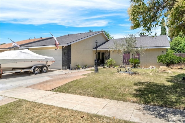 4883 E Geary St, Fresno, CA 93725 - ranch-style home featuring a garage, concrete driveway, stucco siding, and a front lawn
