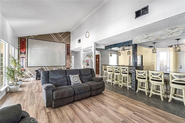 4883 E Geary St, Fresno, CA 93725 - living room featuring a bar, high vaulted ceiling, and wood finished floors