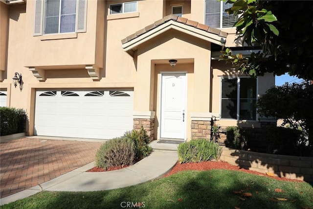 800 W Huntington Dr Unit D, Arcadia, CA 91007 - view of exterior entry with stucco siding, stone siding, an attached garage, and decorative driveway
