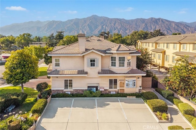 800 W Huntington Dr Unit D, Arcadia, CA 91007 - view of front facade featuring stucco siding, a chimney, a mountain view, a tile roof, and stone siding