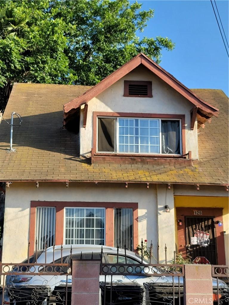 126 W 54th St, Los Angeles, CA 90037 - view of front of home with stucco siding, a shingled roof, and a fenced front yard