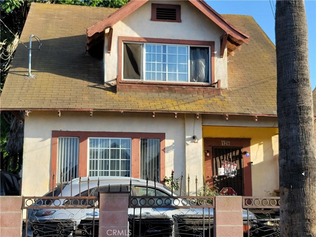 126 W 54th St, Los Angeles, CA 90037 - view of front facade with a shingled roof and stucco siding