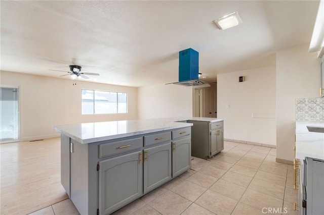 2738 S Fairway Ct, Visalia, CA 93277 - kitchen featuring a kitchen island, gray cabinetry, ceiling fan, and light tile patterned flooring