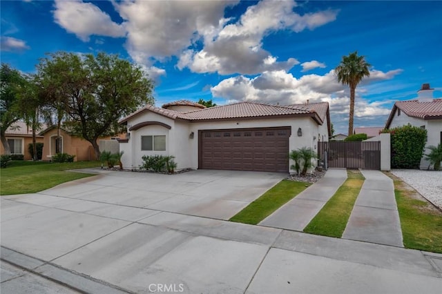 47645 Calle Diamante, Indio, CA 92201 - mediterranean / spanish-style home with stucco siding, a tile roof, a gate, an attached garage, and concrete driveway