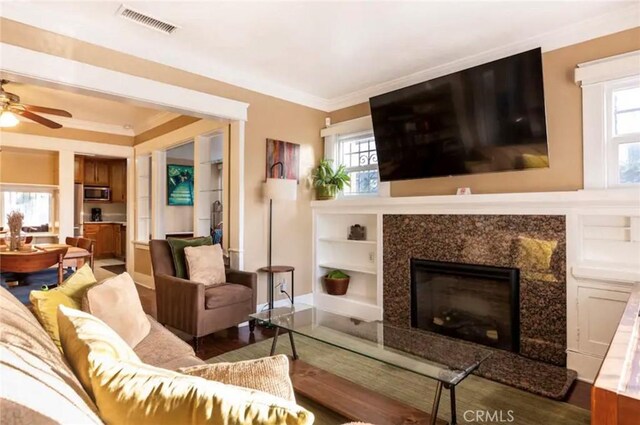 5162 S Manhattan Pl, Los Angeles, CA 90062 - living room featuring ceiling fan, ornamental molding, built in shelves, a high end fireplace, and wood finished floors