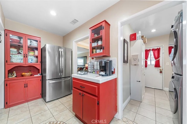 4303 E De Ora Way, Long Beach, CA 90815 - kitchen with freestanding refrigerator, stacked washer / drying machine, light tile patterned floors, tile counters, and recessed lighting
